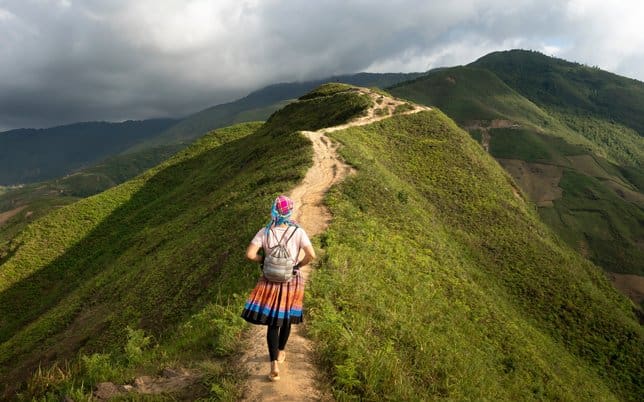 A woman walking down the side of a mountain.